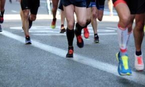 people running on gray asphalt road during daytime