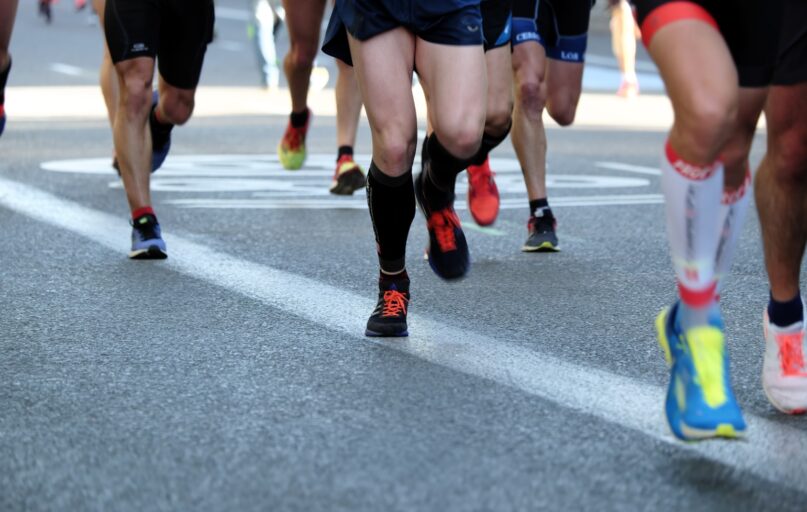 people running on gray asphalt road during daytime