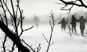 a group of people walking across a snow covered field