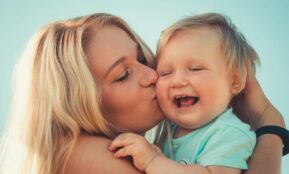 woman in teal shirt carrying girl in teal shirt