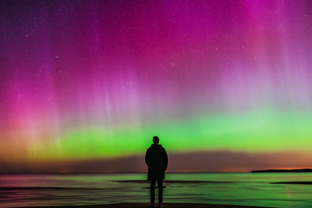 A person watches the aurora borealis.