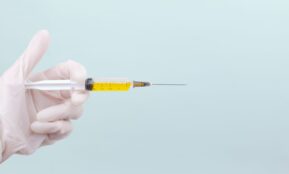 person holding yellow and white pen