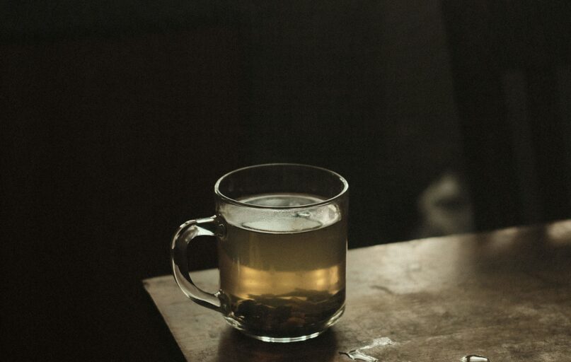 clear glass mug with brown liquid