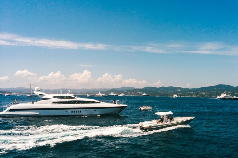 white and blue boat on sea under blue sky during daytime