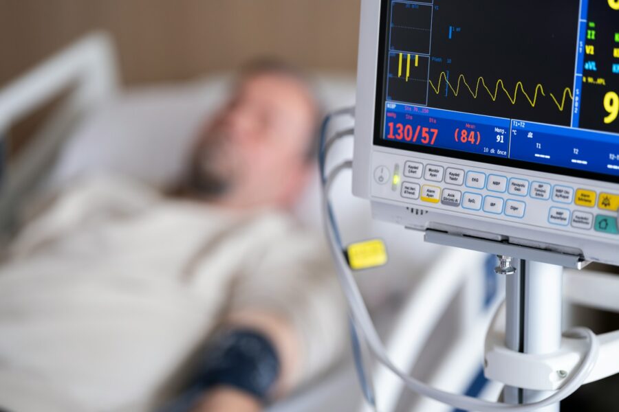 a man laying in a hospital bed next to a monitor