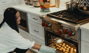 woman in white long sleeve shirt and black and white hijab standing in front of stainless