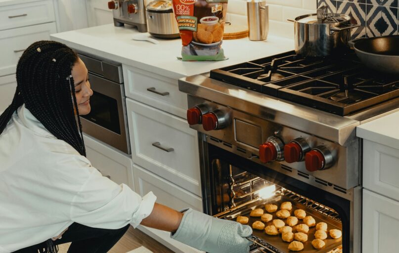 woman in white long sleeve shirt and black and white hijab standing in front of stainless