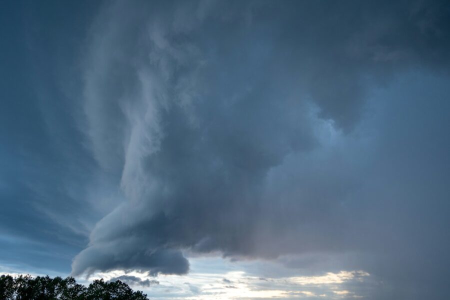 a very large cloud in the sky over a field