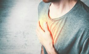 a man holding his chest with his hands