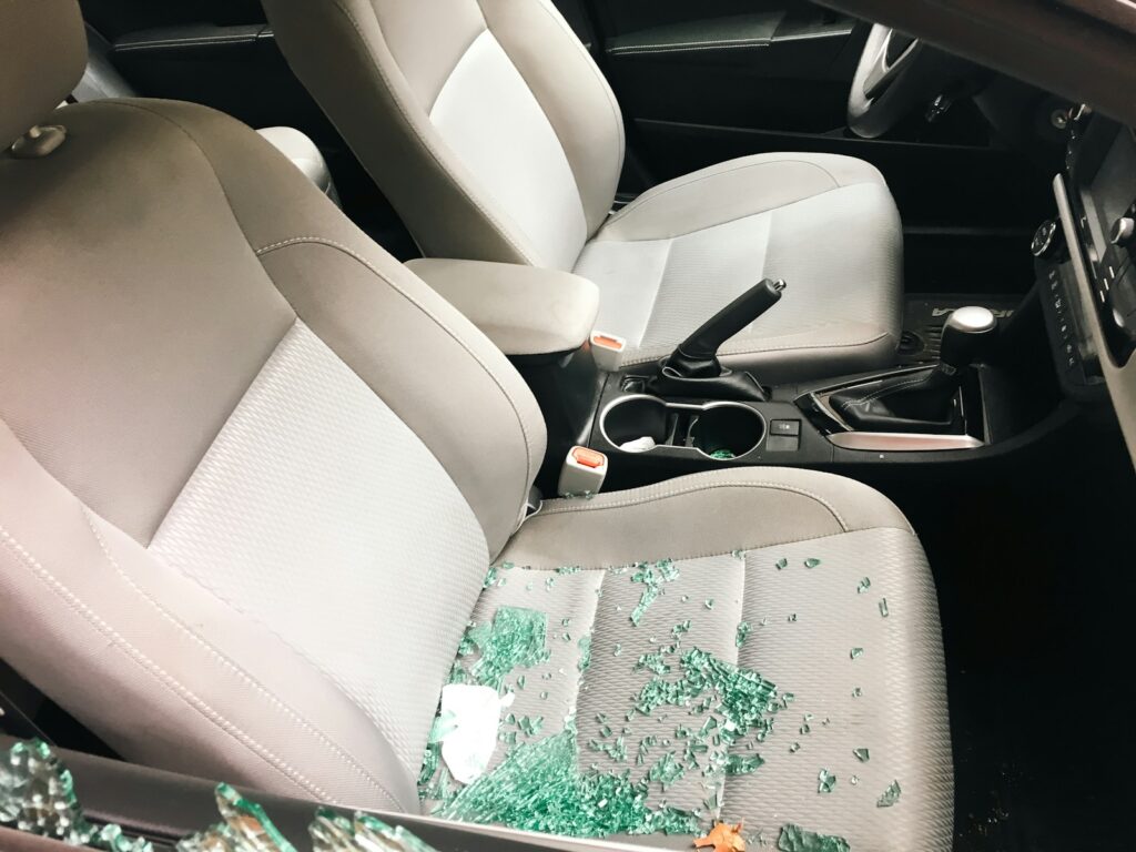 Car interior with shattered glass from a broken window.