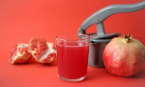 clear drinking glass with red liquid beside red apple fruit