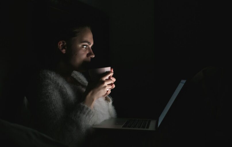 a person sitting in front of a laptop