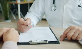 Doctor writing on a patient's chart
