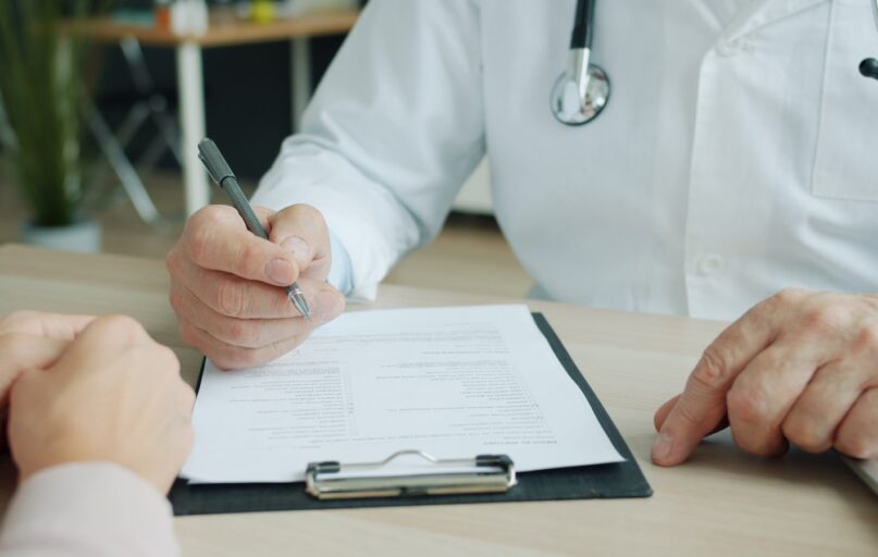 Doctor writing on a patient's chart