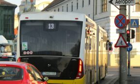 A city street filled with traffic next to tall buildings