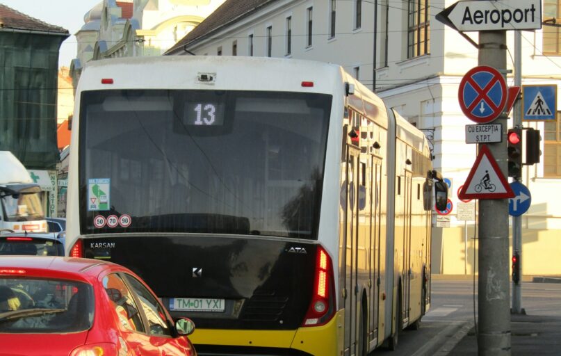 A city street filled with traffic next to tall buildings