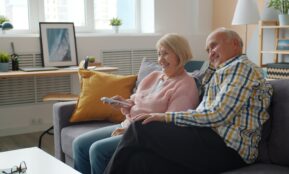 Elderly couple relaxing on a couch watching television