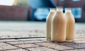 two white glass bottles on brown wooden table