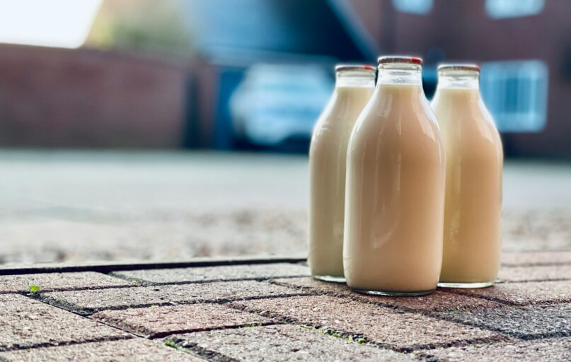 two white glass bottles on brown wooden table