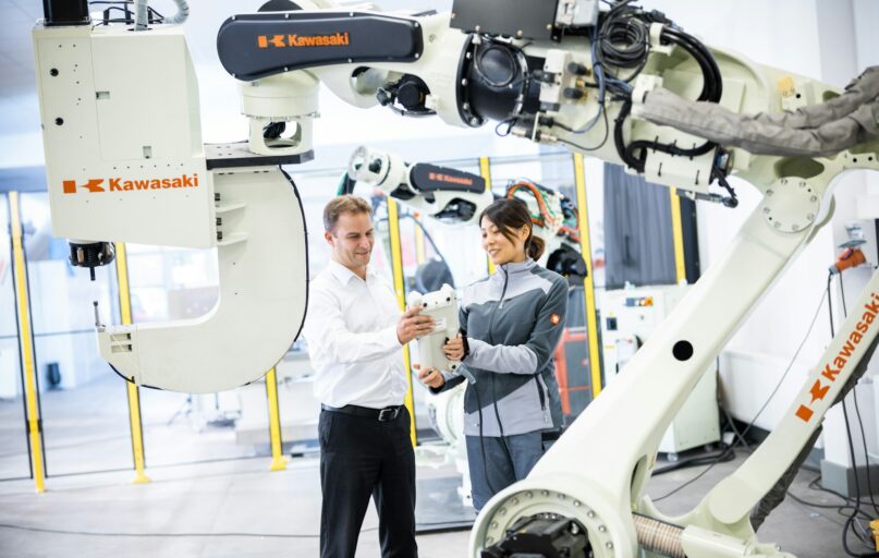 a man and a woman standing in front of a robot