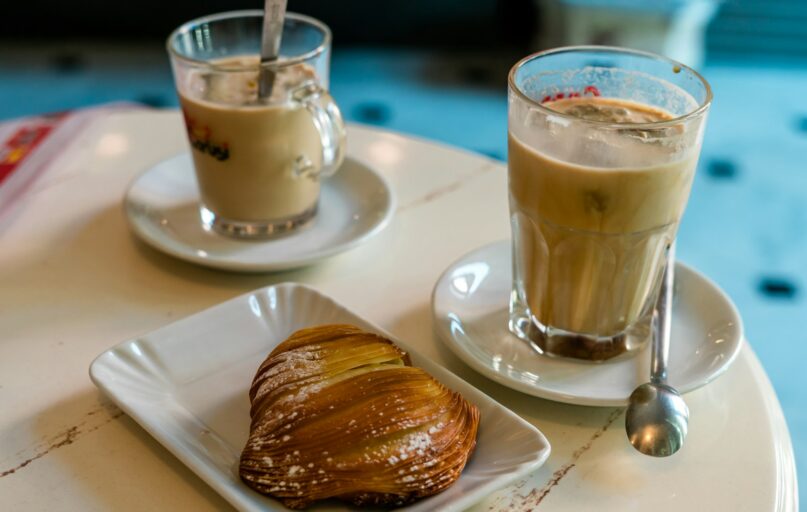 clear glass mug with brown liquid on white ceramic saucer