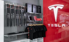 a store with a red wall and a tesla logo on the wall