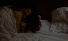 woman lying on white bed comforter