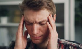 a man holding his hands to his ears