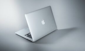 silver macbook on white table