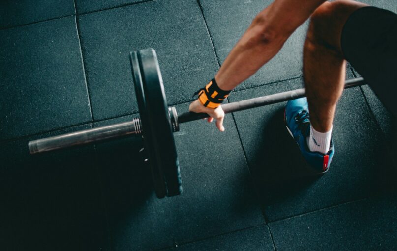 man holding black barbell