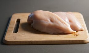 a piece of raw chicken on a cutting board