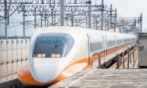 a white and orange train traveling down train tracks