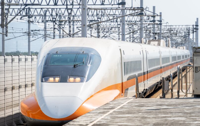 a white and orange train traveling down train tracks