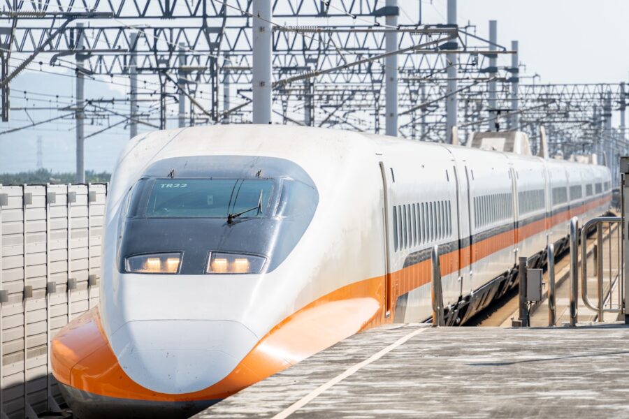 a white and orange train traveling down train tracks