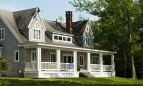 white and brown wooden house near green trees during daytime
