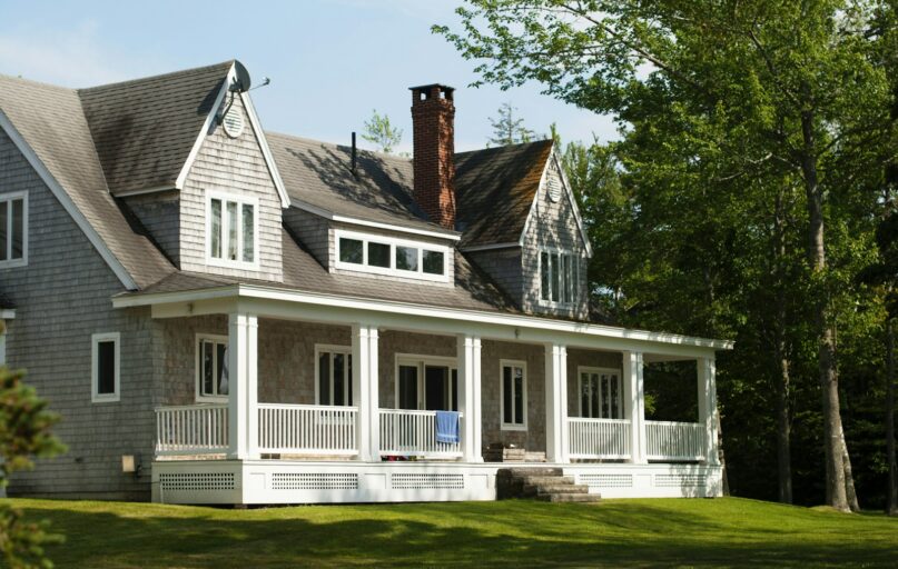 white and brown wooden house near green trees during daytime