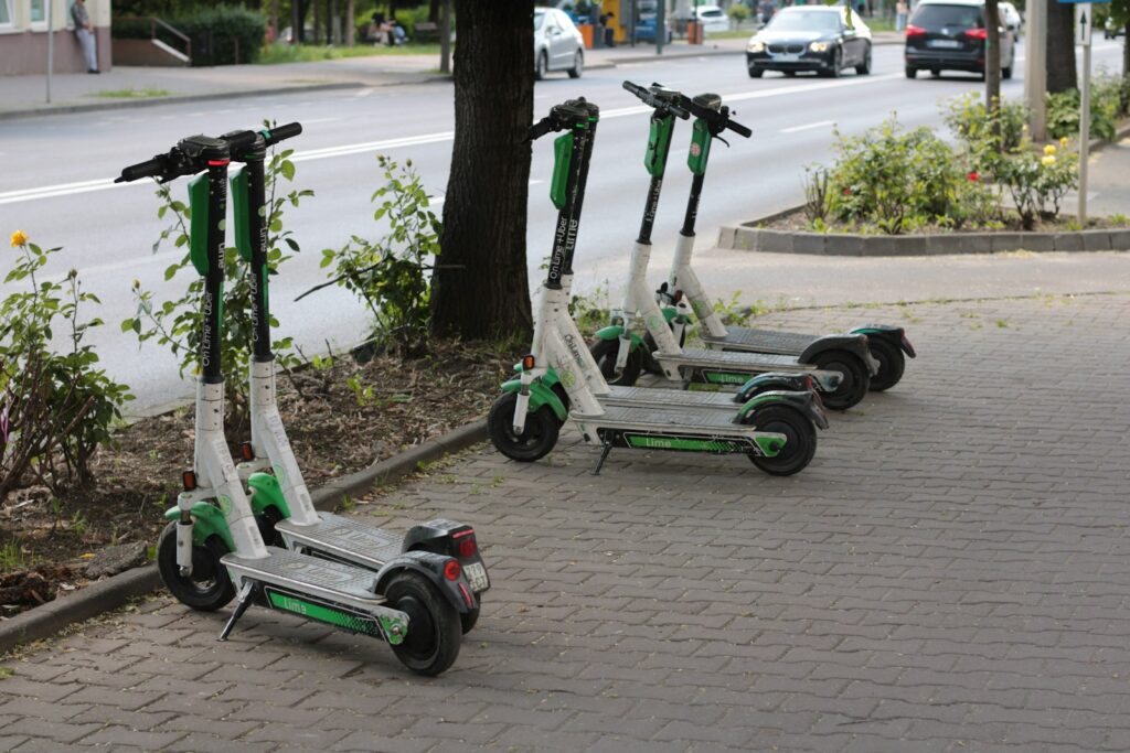 three green and white scooters parked on the side of the road