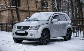 a white suv is parked in the snow