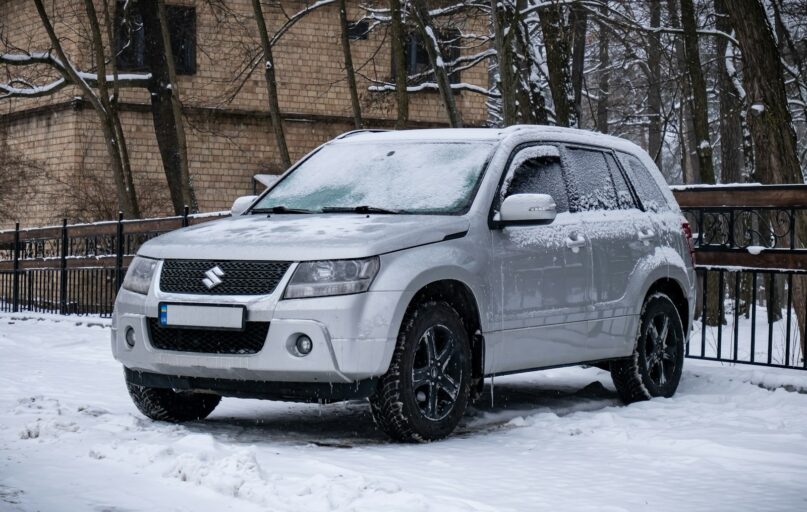 a white suv is parked in the snow