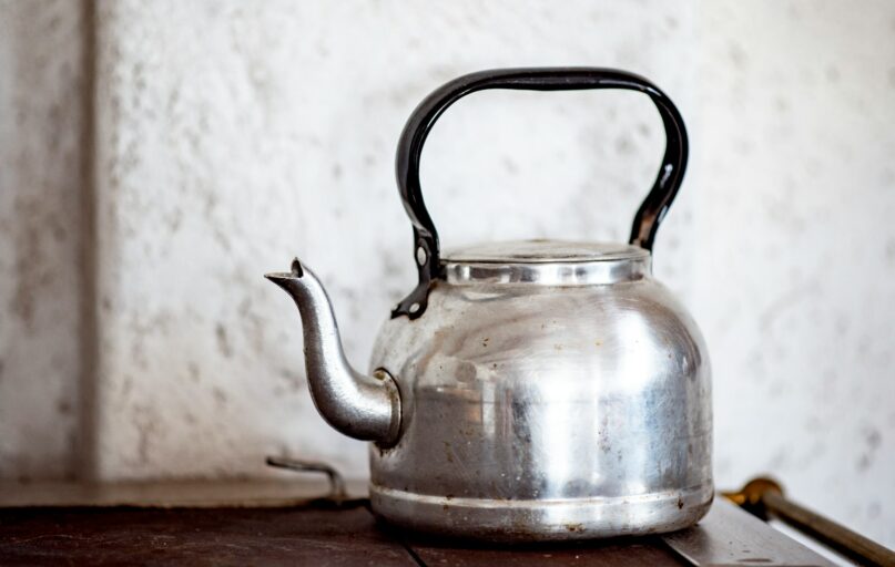 stainless steel kettle on brown wooden table