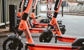 a group of orange scooters parked next to each other