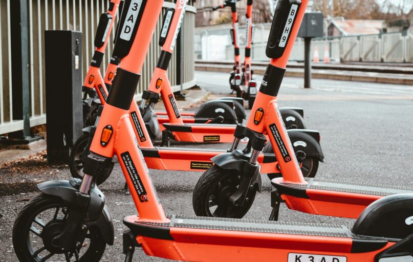 a group of orange scooters parked next to each other
