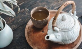 white and brown ceramic teapot on wooden tray