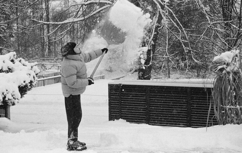 Person shoveling snow in a winter landscape