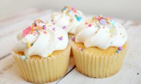 three cupcakes on white wood