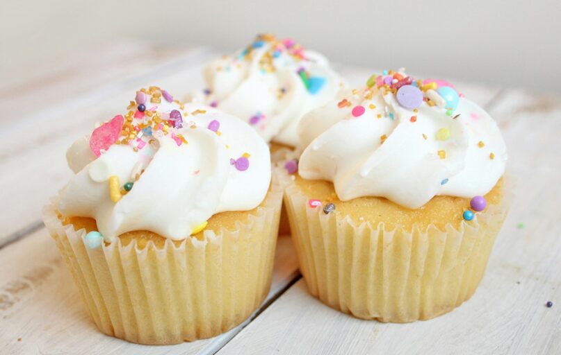 three cupcakes on white wood