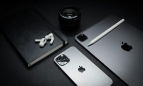 silver macbook beside black camera lens and black camera lens