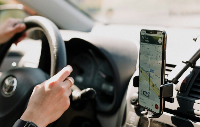 a person using a cell phone while driving a car
