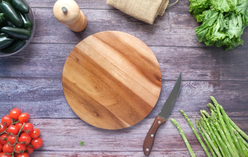 brown wooden chopping board beside green vegetable
