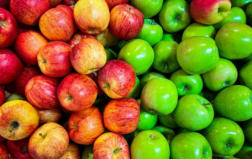 green and red apples on white plastic container
